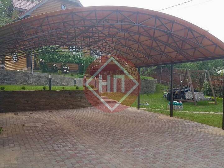 большой арочный навес для участка с деревянным домом